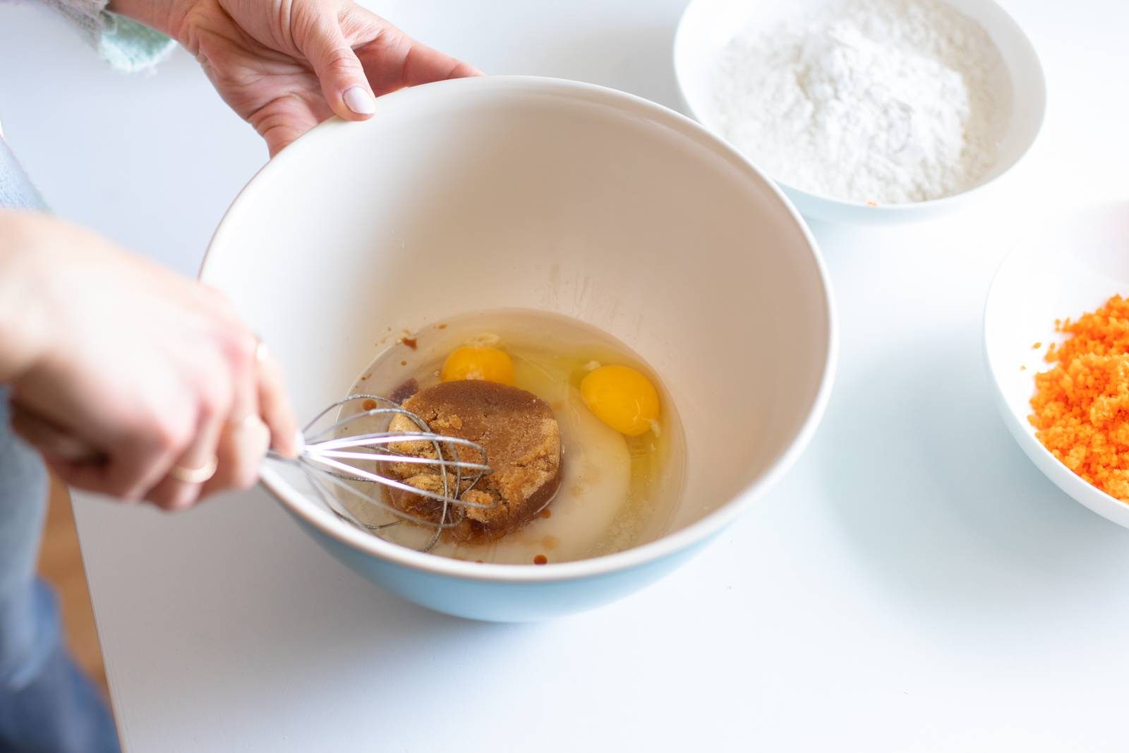Whisking eggs and sugar in a bowl.