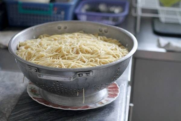 Cooked spaghetti in a colander.