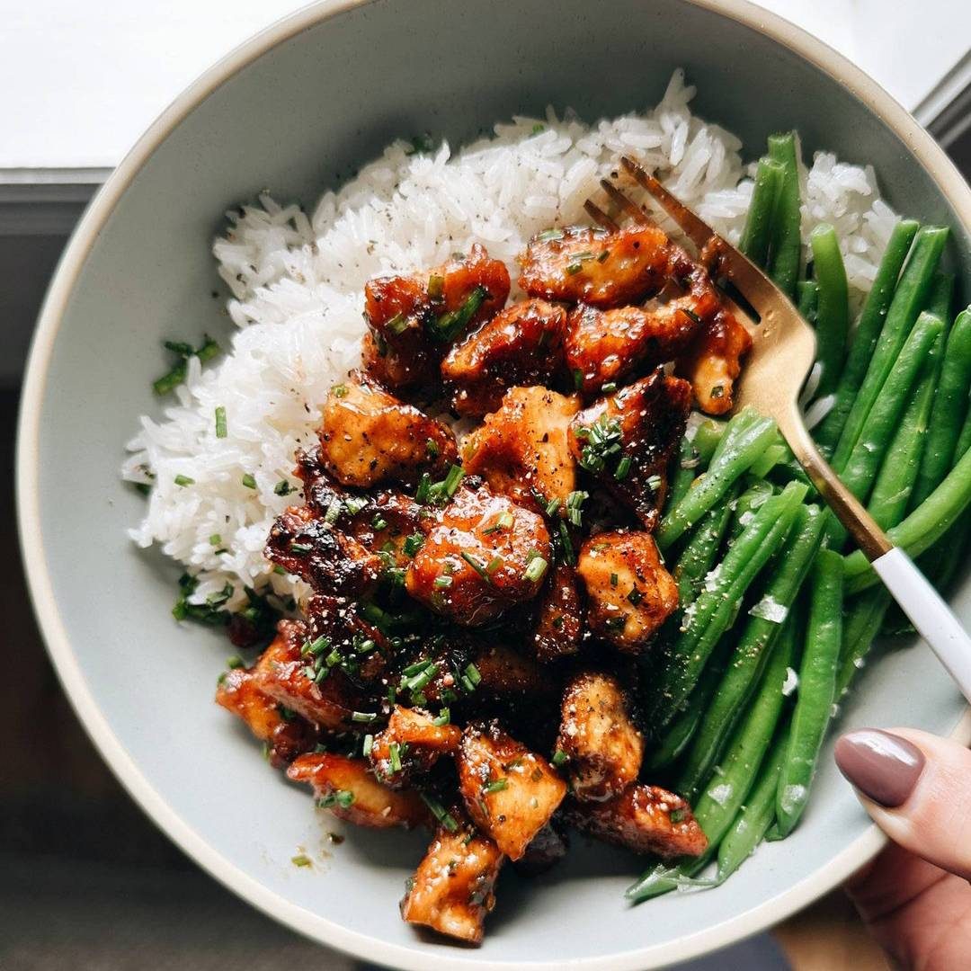 Sesame tofu in a bowl with rice and green beans.
