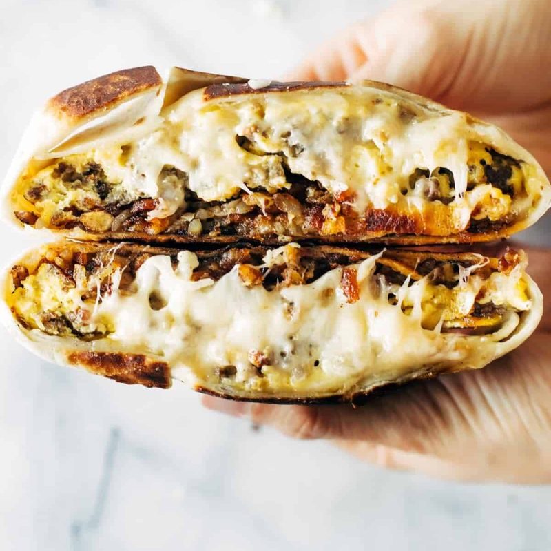 Breakfast Crunchwrap held in a hand.