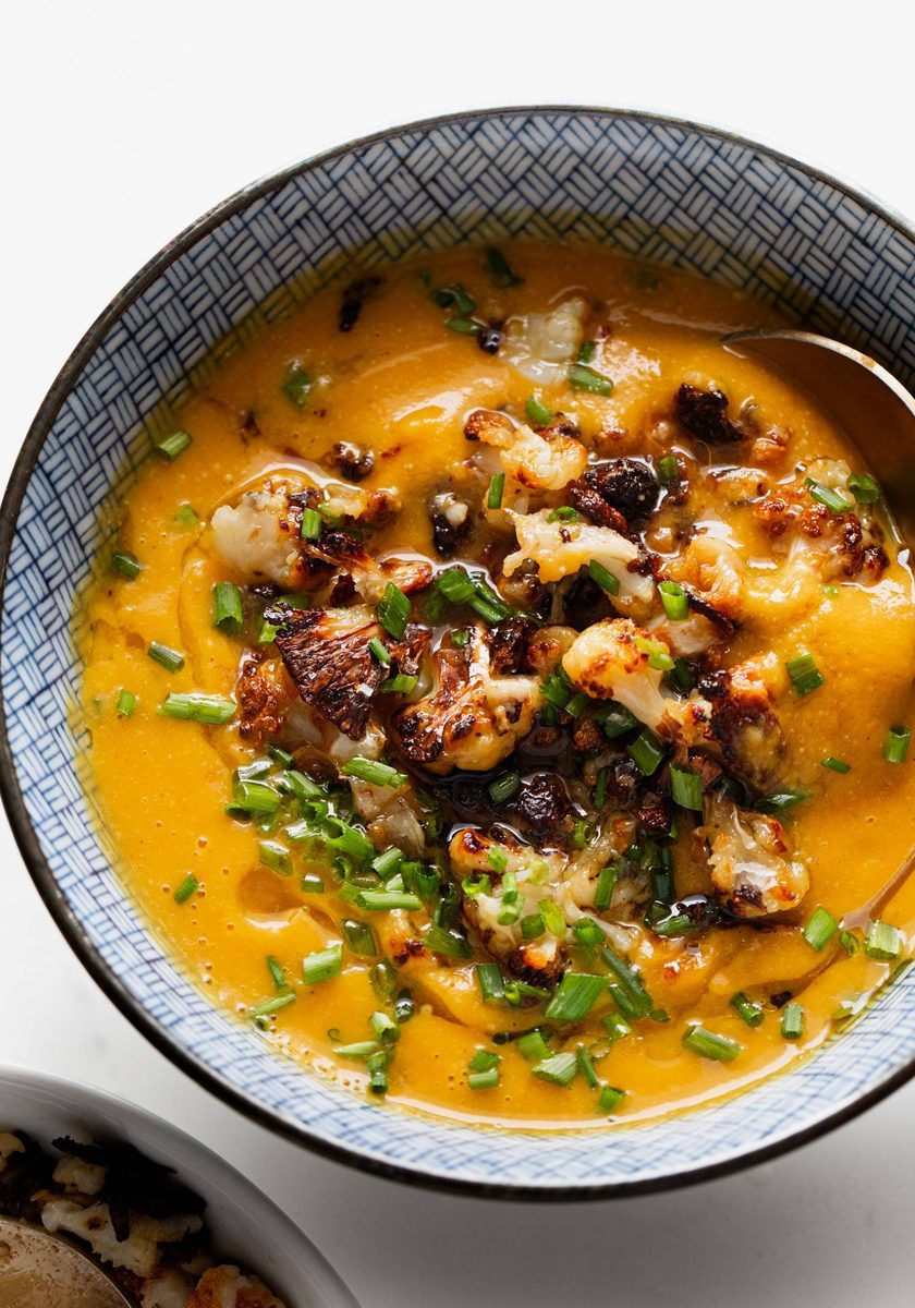 Sweet potato soup in a bowl topped with cauliflower crumbles.