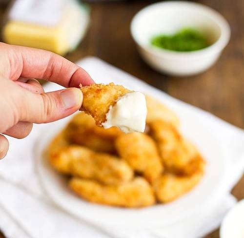 Parmesan chicken fingers dipped in a homemade garlic cheese sauce.