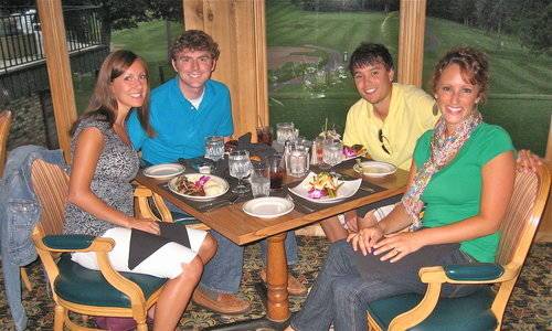 Four people sitting around a table eating.