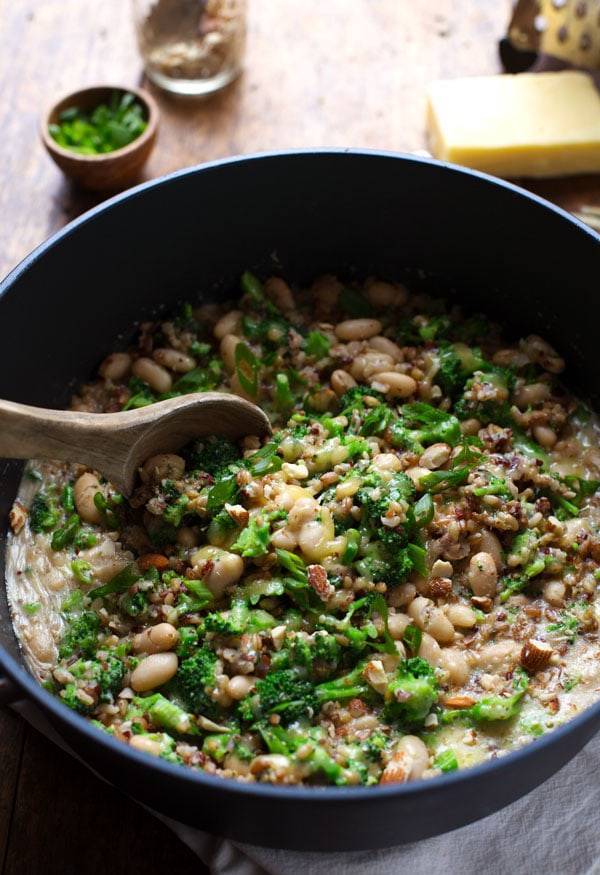 Broccoli Cheese Rice in a pan with a wooden spoon.