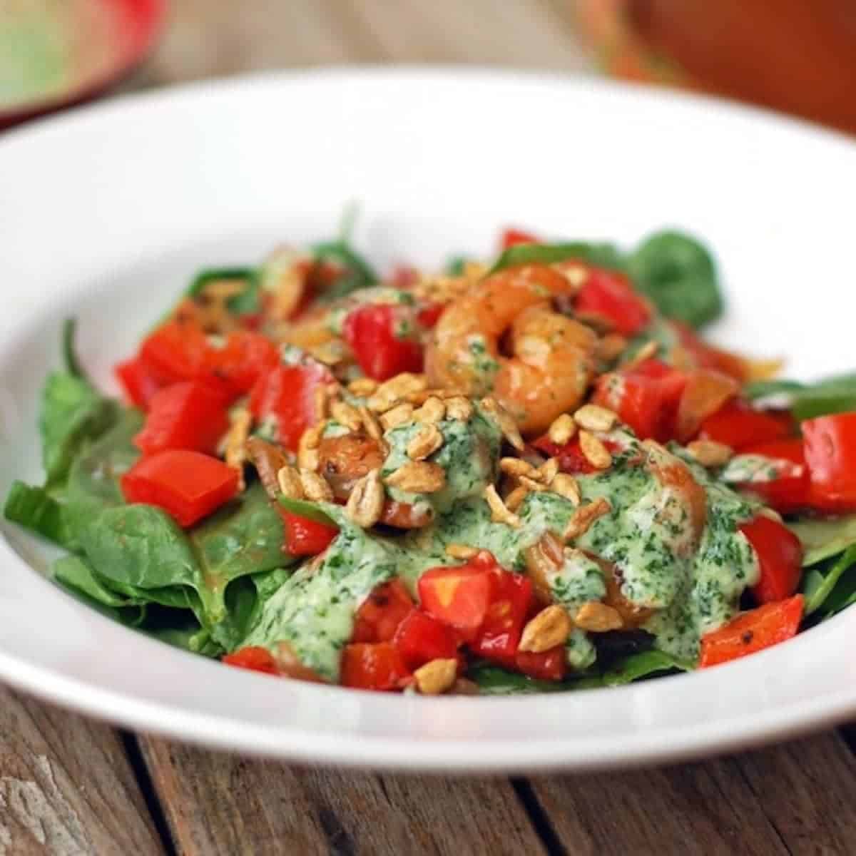 Creamy cilantro dressing on lettuce in a white bowl.