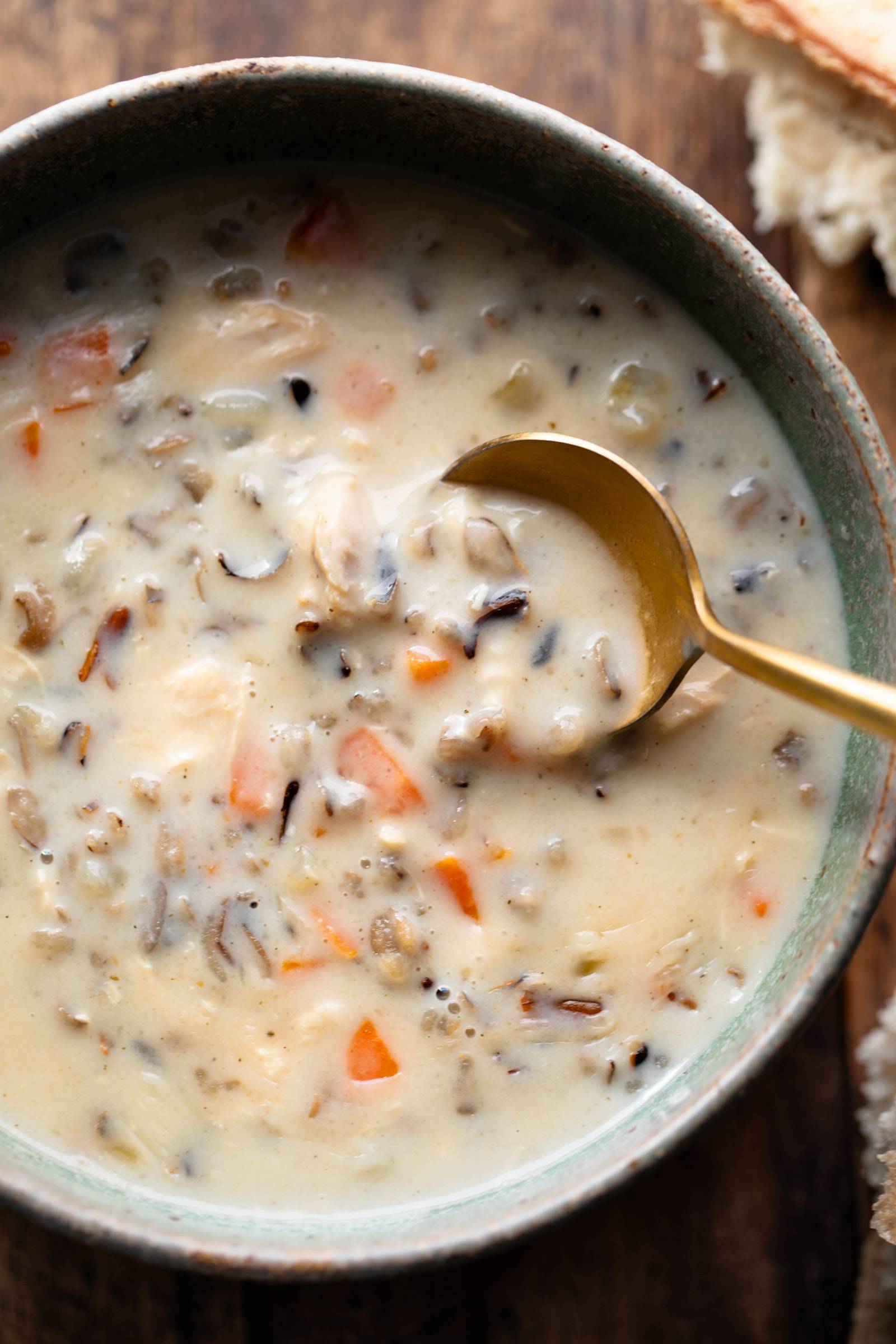 Wild rice soup in a bowl with a spoon.