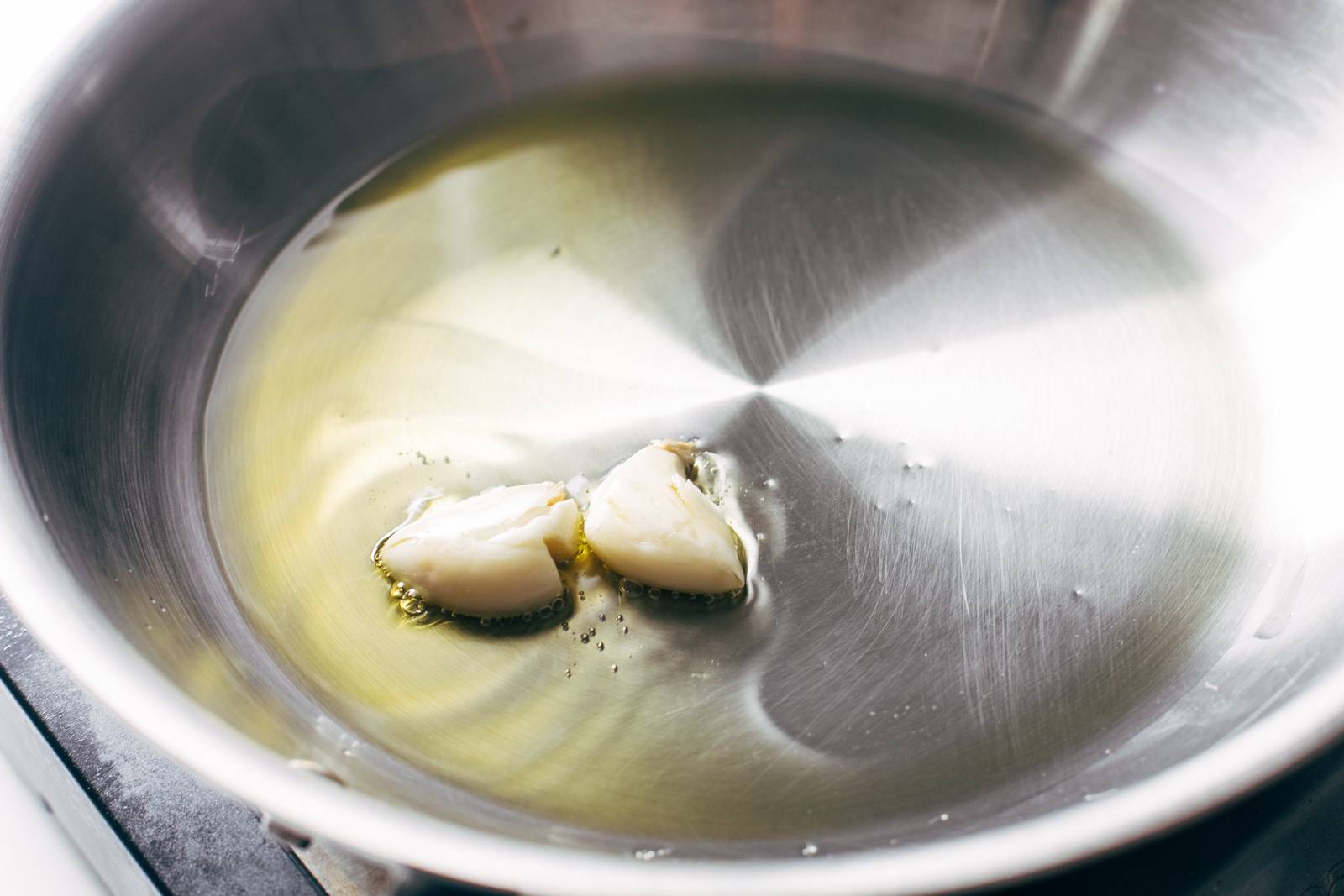 Sautéing smashed garlic cloves in oil.