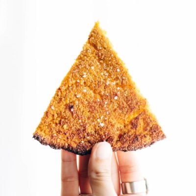 Sweet Potato Pizza Crust slice held by hand.